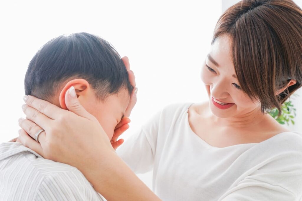 泣く子供となぐさめる母親